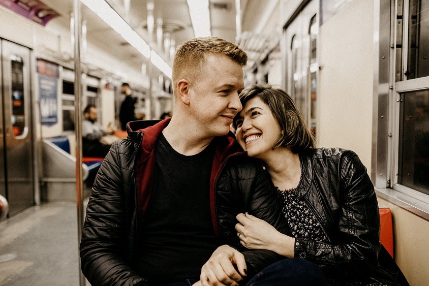 זוג צעיר יושב ברכבת ונראה מאושר