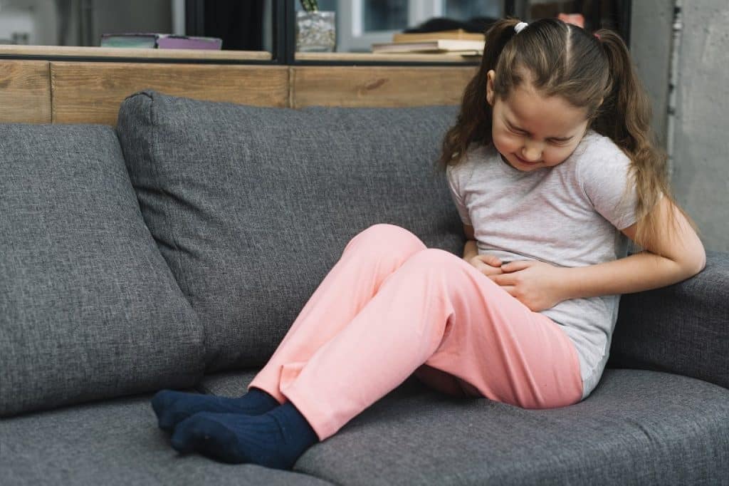 ילדה קטנה עם וירוס בבטן במנוחה על הספה