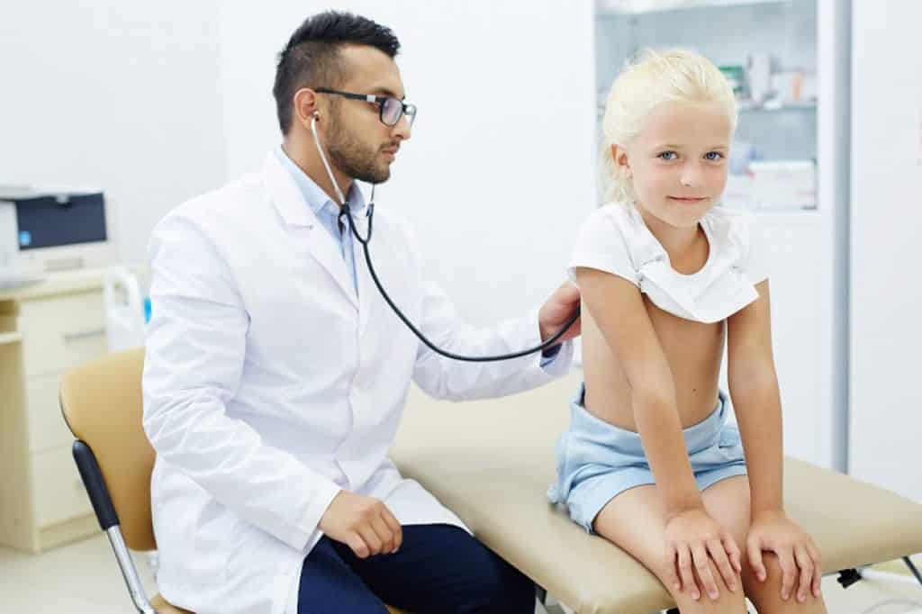 רופא בודק את הנשימה של ילדה קטנה