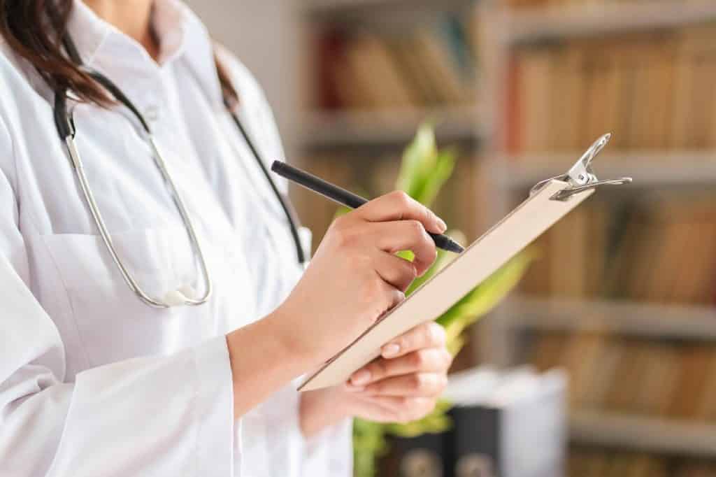 רופאה מחזיקה לוח קשיח עם רשימה של בדיקות